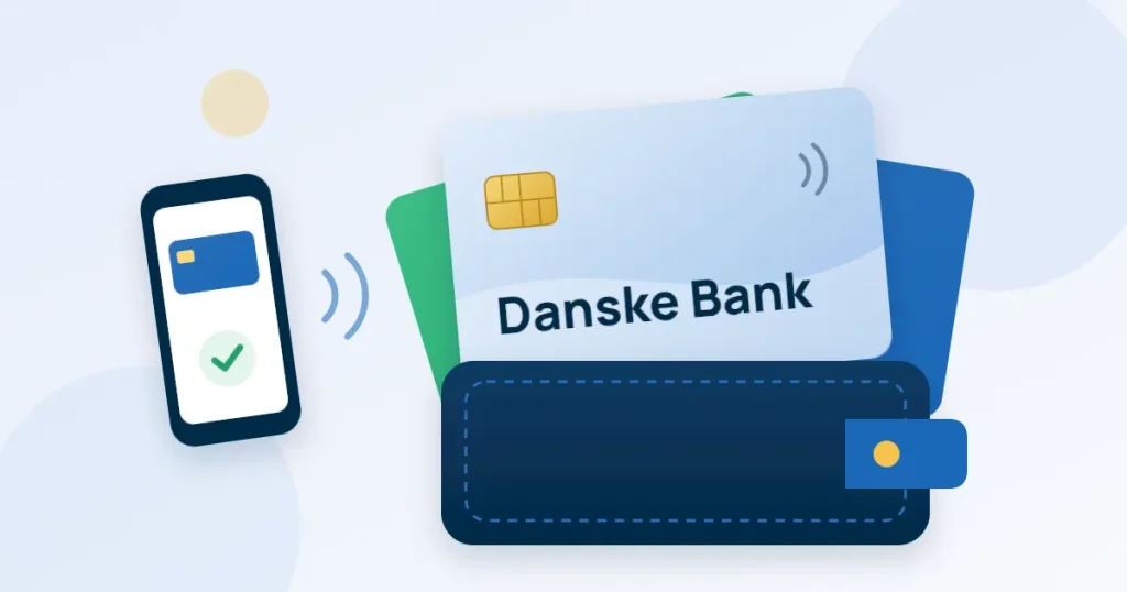 Ett ljusblått kreditkort med texten Danske Bank sticker upp ur en plånbok med två andra kort, bredvid en mobil som betalar kontaktlöst.